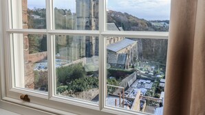 A view through a window with a brick wall and a stone tower in the background. - 26 Frenchgate (Richmond)