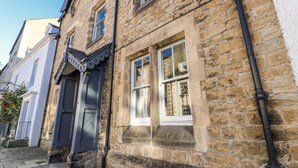 A stone building with a traditional facade, featuring a large window with a white frame and a door with a dark-colored door frame. - 26 Frenchgate (Richmond)