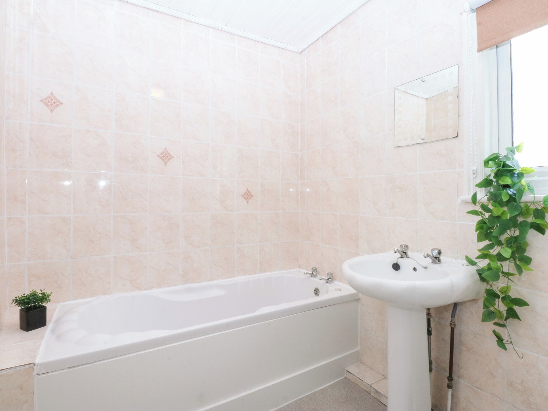 Een badkamer met een bad, een wastafel en een spiegel.