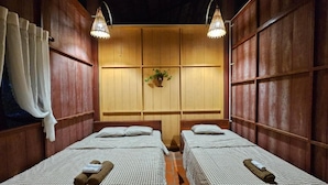 Une chambre avec deux lits, un lambris en bois et deux lampes suspendues.