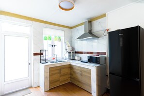 A compact kitchen with a sink, microwave, and refrigerator. - Serene 3-bedroom apartment with AC in Grand Baie 3mins from beach (Grand Baie)