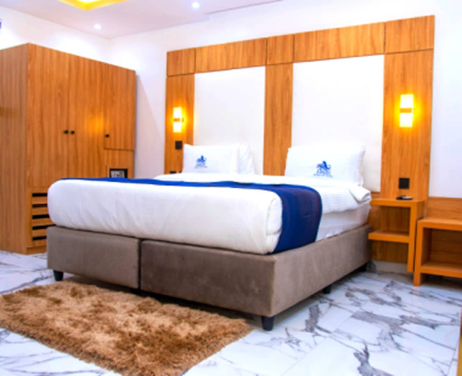 A bedroom with a large bed, wooden headboard, and two bedside lamps.