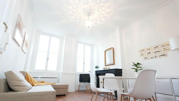 Ein modernes Wohnzimmer mit einer Couch, Sesseln, einem Kamin und Kunstwerken an den Wänden.