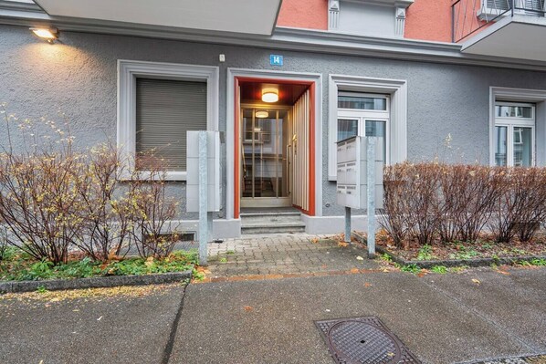A building entrance with a door, steps, and a mailbox.