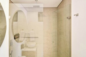 Ein modernes Badezimmer mit Duschkabine aus Glas, Waschbecken und Toilette.