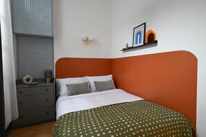 Une chambre à coucher bien aménagée, avec un lit, une table de chevet, une étagère murale décorative et un panneau mural à motifs.