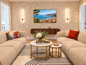 A living room with two sofas, a coffee table, a decorative vase, and a framed painting on the wall. - Scarlett - 4 Bedroom next to the Croisette (Cannes)