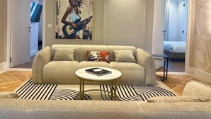 A living room with a sofa, a coffee table, and a painting on the wall. - Scarlett - 4 Bedroom next to the Croisette (Cannes)