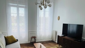 Ett vardagsrum med en soffa, ett soffbord, en tv och ett element.