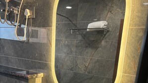 Casa de banho moderna com uma pia branca, um espelho com moldura dourada e um porta-toalhas.