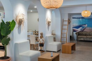 Een modern interieur met witte meubels, een grote potplant en een muurschildering van een boot.