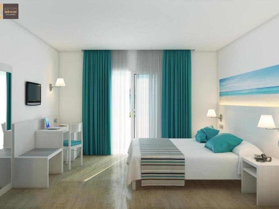 A hotel room with a bed, bedside tables, a desk, a chair, a TV, and a painting of a beach.