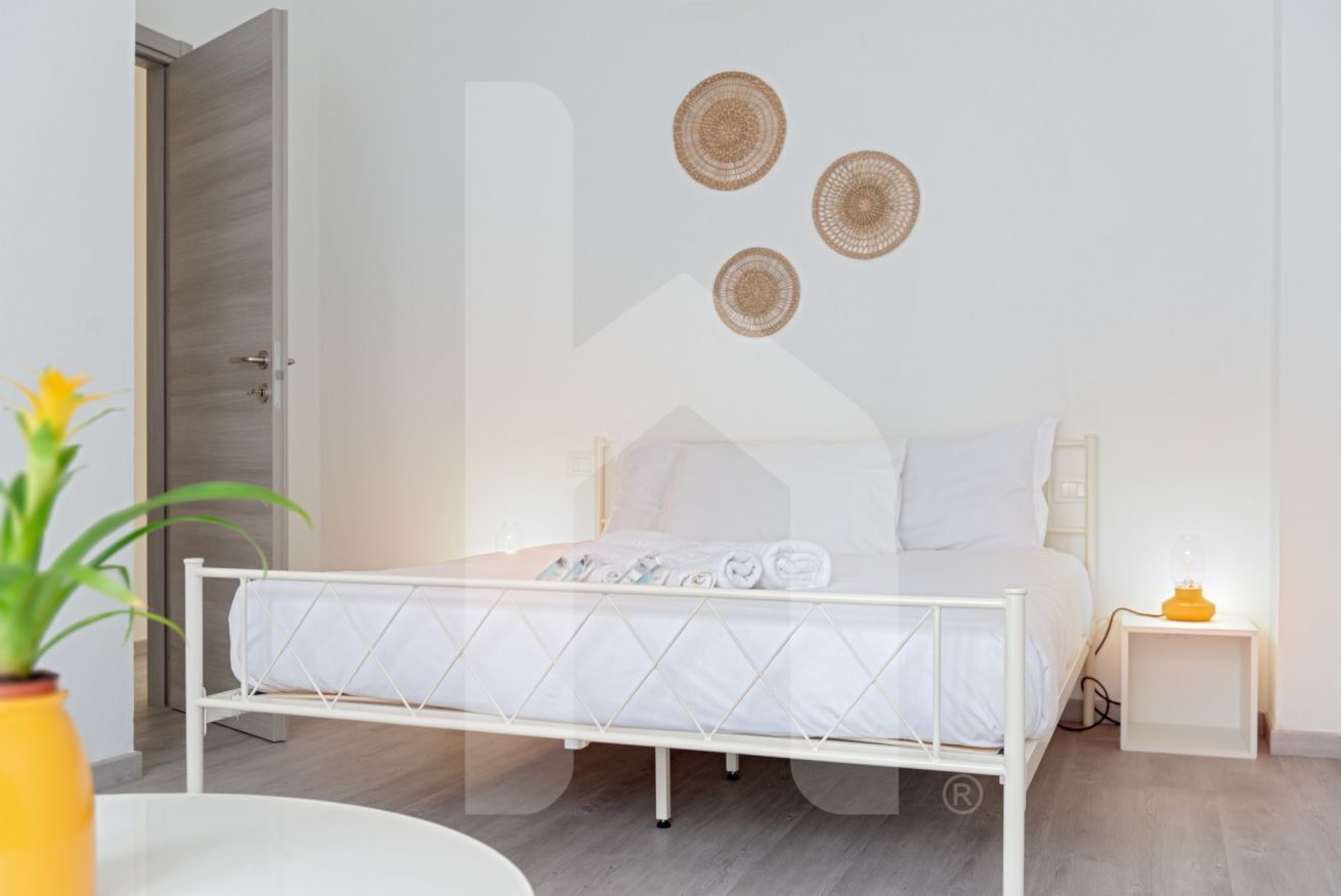Ein Schlafzimmer mit Bett, Nachttisch und Wandleuchte.