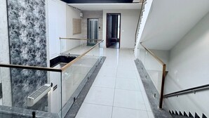 Ein modernes Interieur mit einer Glasstiege, einer Marmorwand und Blick durch ein Oberlicht.