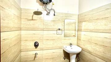 Un baño pequeño con inodoro, lavamanos y ducha.