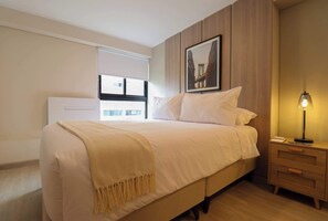 A bedroom with a bed, a nightstand, a lamp, a window with blinds, and a framed picture on the wall. - w Beautiful 2BR w Balcony in Miraflores (Lima)