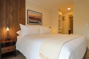 A neatly made bed with white linens, a bedside lamp, and a framed cityscape picture on the wall. - w Ravishing 2BR w Balcony in Miraflores (Lima)