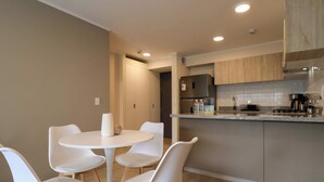 Une cuisine moderne avec une table de salle à manger ronde et quatre chaises blanches.