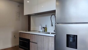 A modern kitchen with a stainless steel refrigerator, a built-in oven, and a sink with a faucet. - w Amazing Loft in the Heart of Bogot (Bogotá)