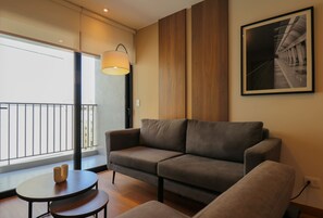 A modern living room with a sofa, a small round table, and a large window with a view of buildings. - w Dreamlike 2BR w Balcony in Miraflores (Lima)