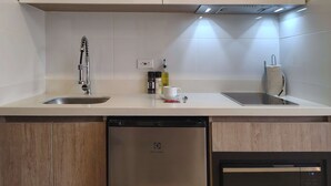 A modern kitchen with white cabinetry, a stainless steel sink, and a dishwasher. - w Wonderful Loft in the Heart of Bogot (Bogotá)
