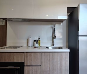 A modern kitchen with a stainless steel sink, a built-in oven, and a microwave. - w Enchanting Loft in the Heart of Bogot (Bogotá)