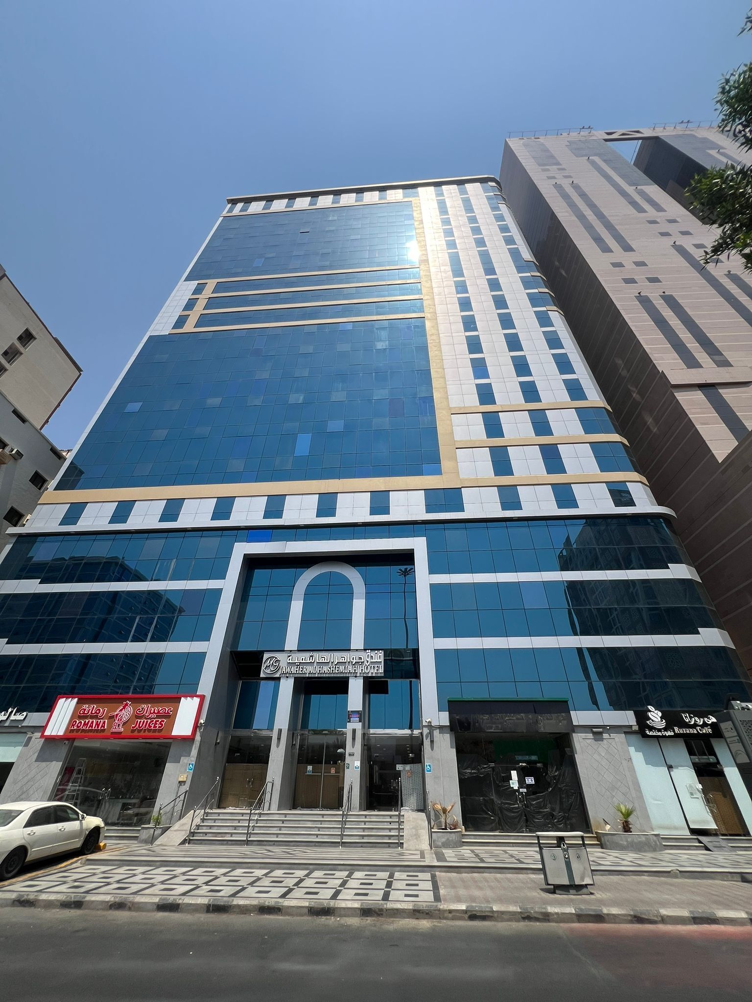 A modern hotel with a glass facade, a prominent entrance, and a sign for the Wahariah Hotel.