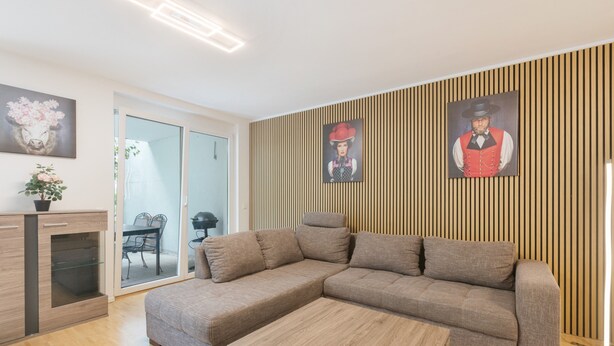 A modern living room with a sectional sofa, a wooden coffee table, and a glass cabinet.