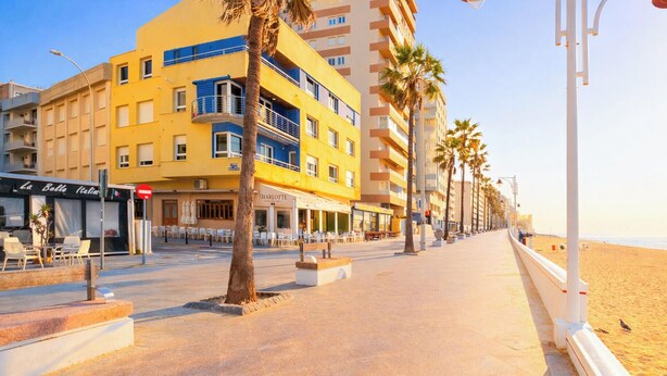 A coastal promenade with a row of buildings, including a yellow building with balconies and a restaurant named 'Charlotte.' - Double room - IMAR Hostel by Cadiz4Rentals (Cádiz)