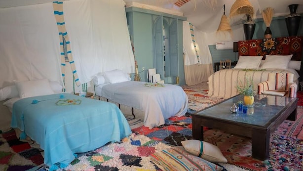 A room with two beds, a sofa, a coffee table, and a patterned rug. - Atlas Aura (Ourika)