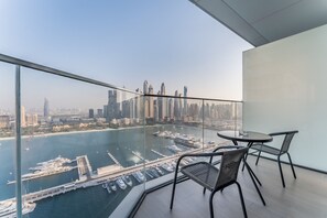A high-rise room with a glass balcony overlooking a marina and city skyline. - Waterfront Community, Beachfront Living Near Dubai Marina and Top Dining Hotspots (Dubai)