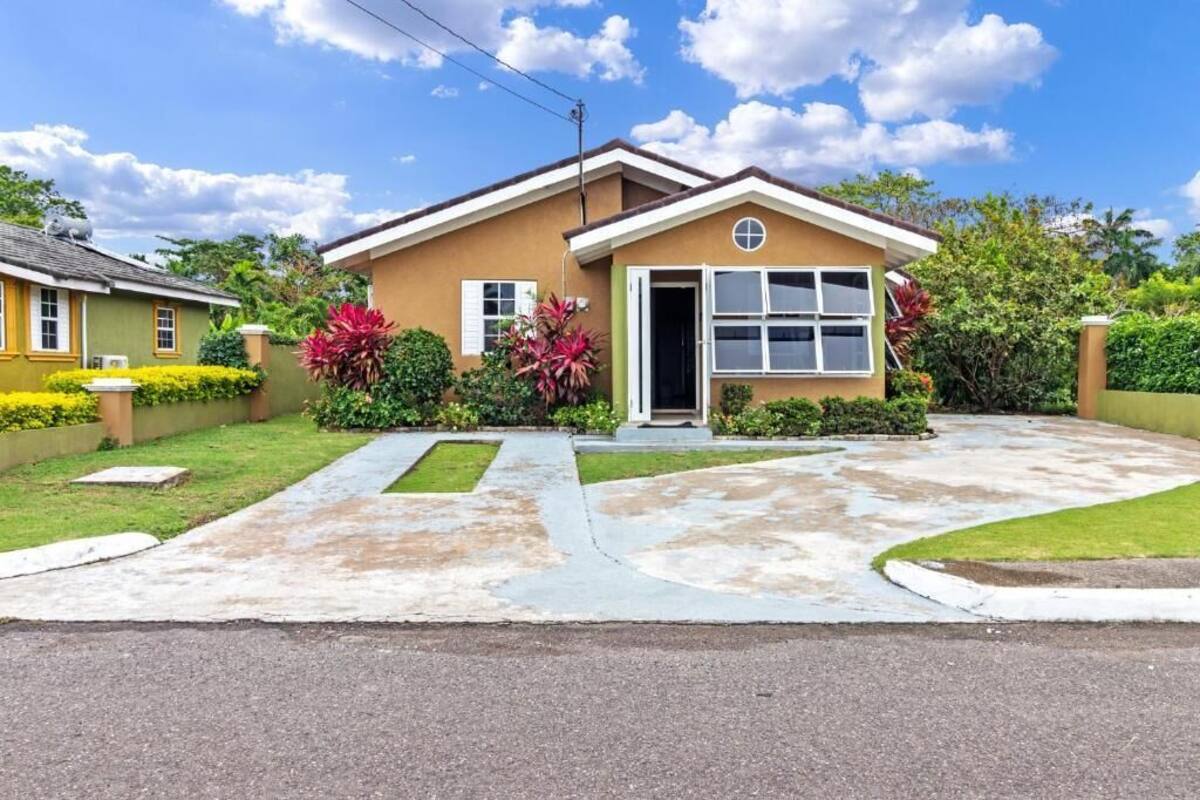 A two-story house with a front entrance, a driveway, and a well-maintained lawn.