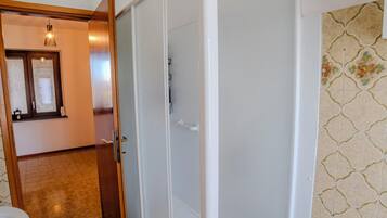 A bathroom with a shower enclosure, a sink, and a toilet.