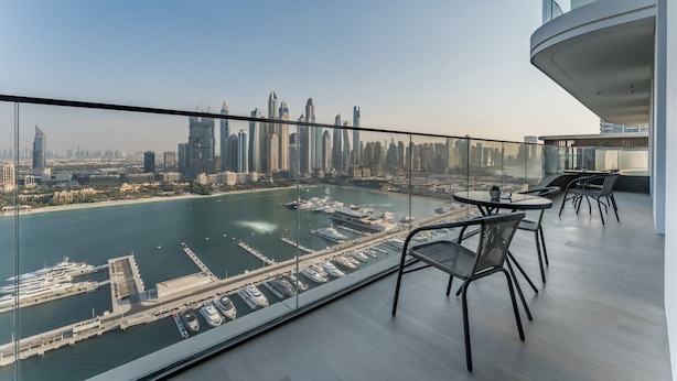 A modern balcony with a glass railing overlooking a marina and city skyline. - Direct Private Beach Access, Proximity To Key Dubai Attractions Like Dubai Marina, Palm Jumeirah (Dubai)