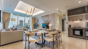 A modern living room with a sofa, dining table, and chairs. There is a kitchen area with cabinets and appliances. - Direct Private Beach Access, Proximity To Key Dubai Attractions Like Dubai Marina, Palm Jumeirah (Dubai)