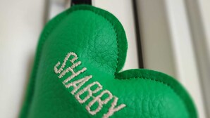 Un llavero verde con forma de corazón que tiene la palabra "SHAPPY" bordada.