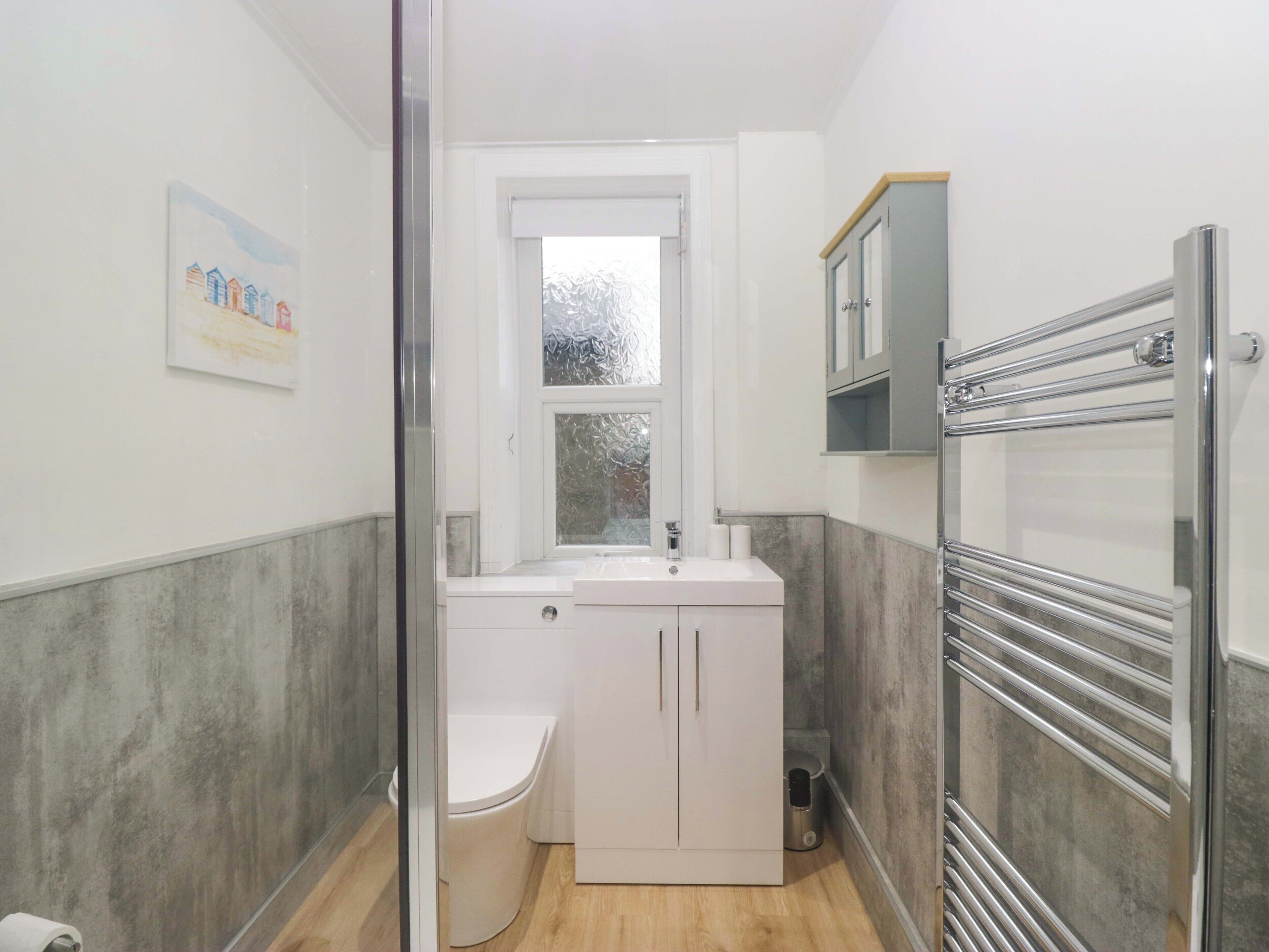 A compact bathroom with a toilet, a sink, and a shower area.