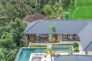 A modern house with a swimming pool, surrounded by lush greenery. - Villa The Kayu by GORO (Kabupaten Gianyar)