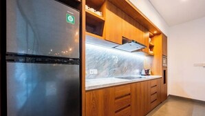 Eine moderne Küche mit Holzschränken, einer Marmorarbeitsplatte und einem Edelstahlkühlschrank.