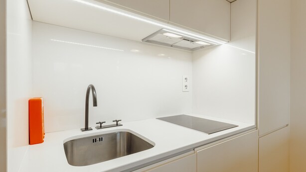 A modern kitchen with a stainless steel sink, a double faucet, and a built-in oven. - Historical Taipas Pink by Vacationy (Porto)
