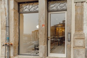 A building entrance with a glass door, a metal gate, and a small sign on the wall. - Historical Taipas Green by Vacationy (Porto)