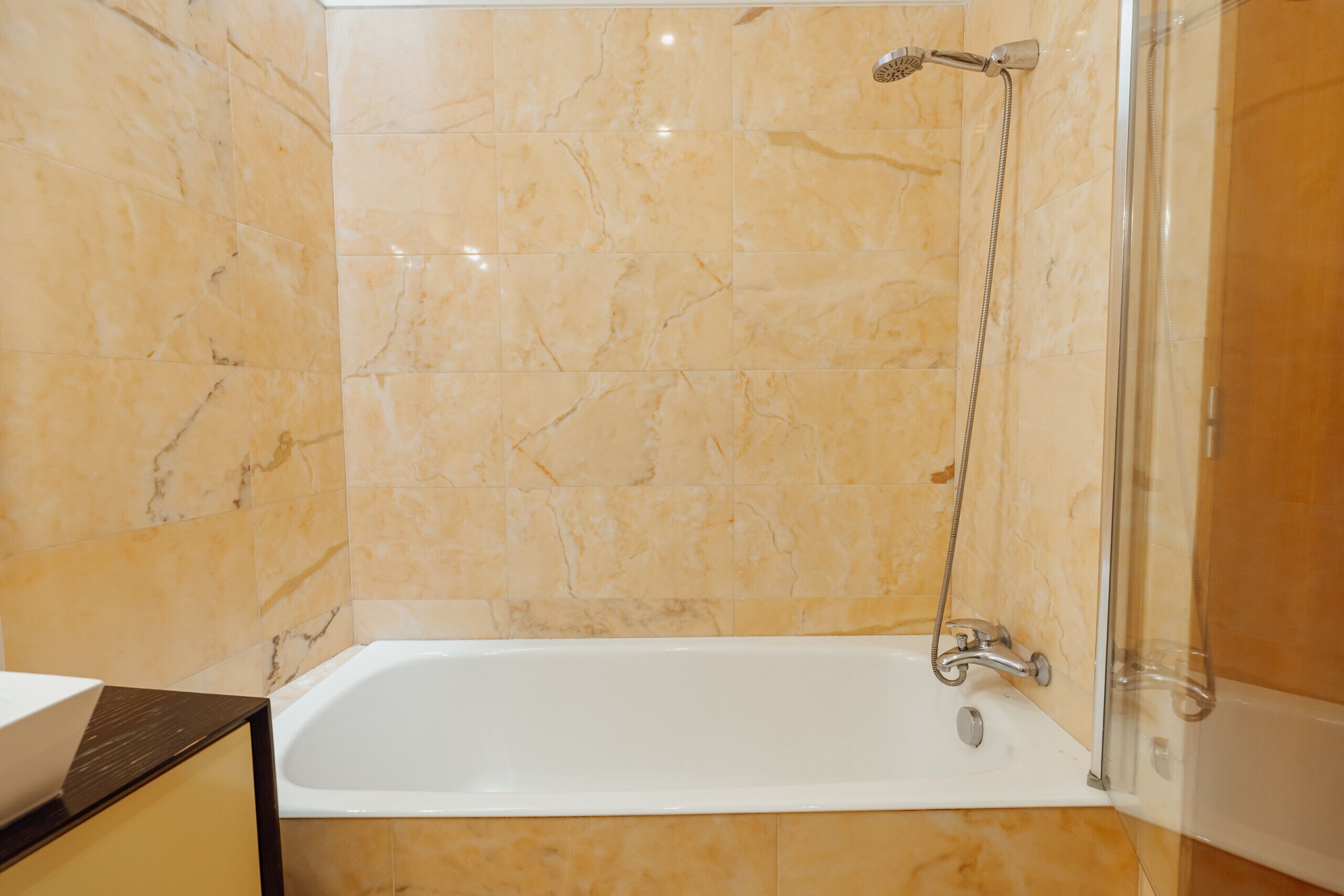 Un bagno con vasca, doccia e pareti in marmo.