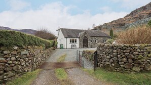 A stone house with a gravel driveway leading to a gate. - Thrang View (Ambleside)