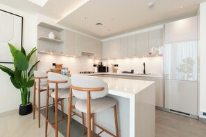 Departamento Deluxe, balcón | Cocina privada | Refrigerador, microondas, horno y parrilla de estufa 