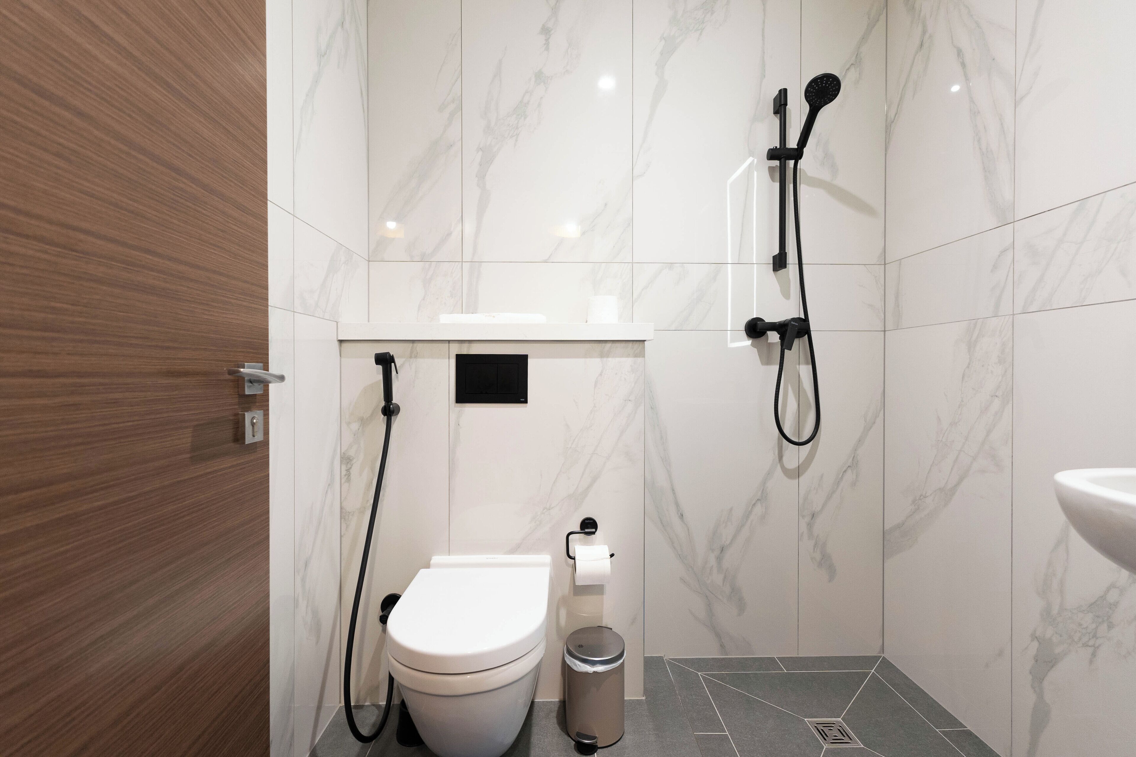 A modern bathroom with a toilet, bidet, and shower.