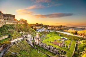 Una antigua fortaleza con ruinas y un campo cubierto de hierba.