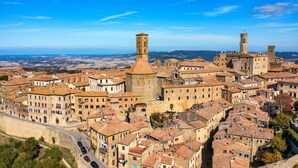 A historic town with medieval architecture, including towers and a fortified wall. -  Berignone Natural Paradise Apt (Volterra)