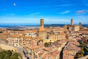 Un pueblo histórico con arquitectura medieval, incluyendo torres y una muralla fortificada.