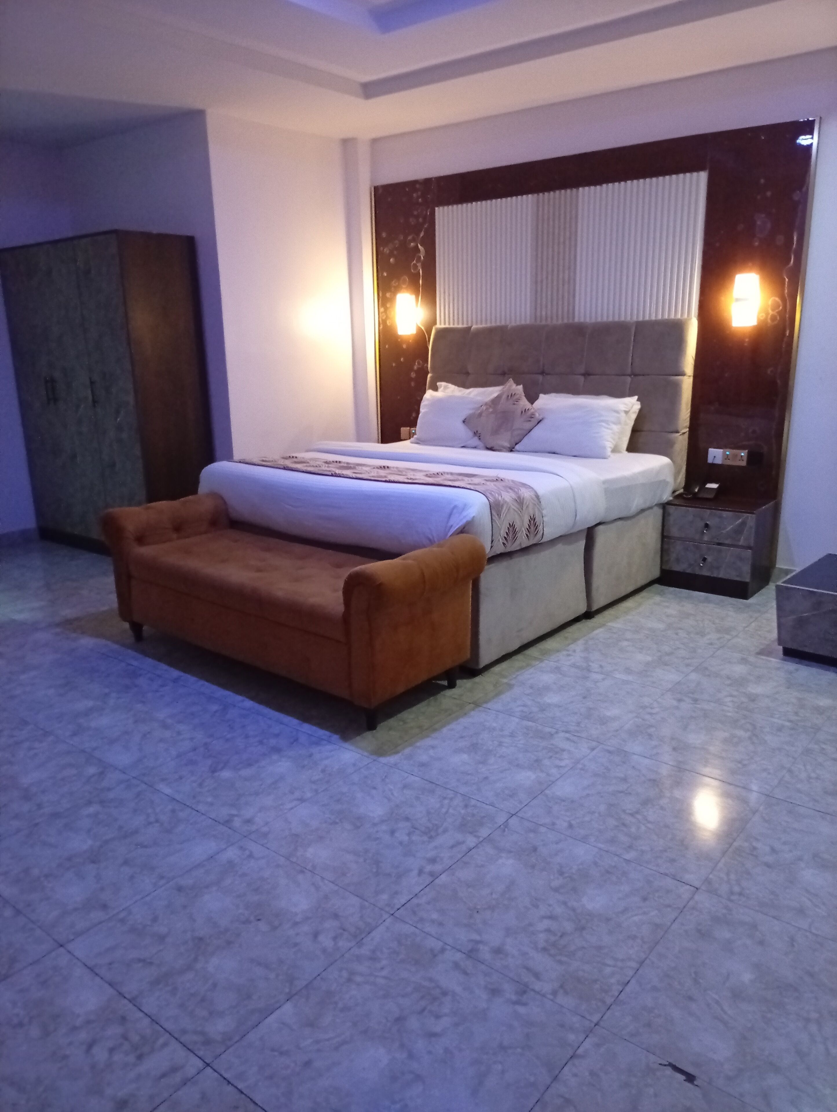 Un dormitorio moderno con una cama grande, una mesita de noche, un sofá y un armario.