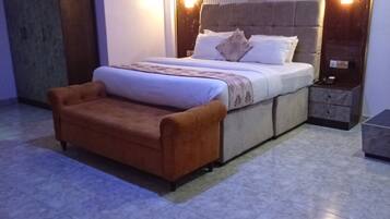 Un dormitorio moderno con una cama grande, una mesita de noche, un sofá y un armario.